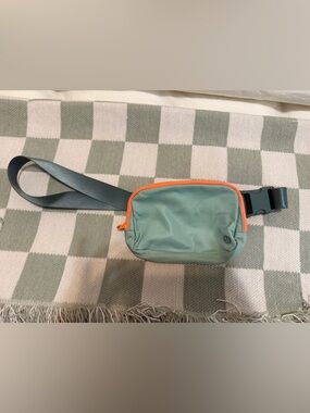 lululemon mint green crossbody bag with bright orange zipper
